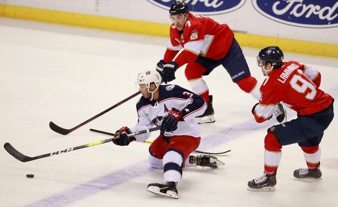 Columbus Blue Jackets defenseman Seth Jones (3) battles for the puck with Florida Panthers right wing Juho Lammikko (91) and center Colton Sceviour (7) during the second period of an NHL hockey game Saturday in Sunrise, Fla. [Wilfredo Lee/The Associated Press]