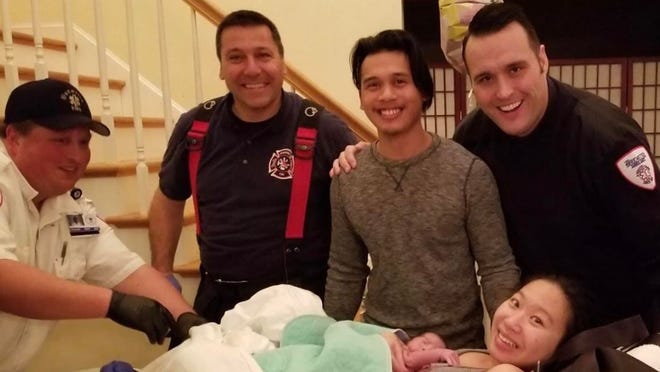 Yunyi Chen with her baby daughter, Amaral, and, from left, paramedic Ken Caron; Braintree firefighter Nick DiMartino; the baby's father, Kevin; and paramedic Johnathon Bobbitt-Miller, at the couple's home in Braintree on Saturday, Jan. 5, 2019. (Brewster Ambulance)