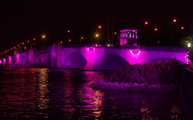 The Promise Fund kicked off a month-long symbol of breast and cervical cancer awareness by lighting the Royal Park Bridge pink Friday night. [Damon Higgins/palmbeachdailynews.com]