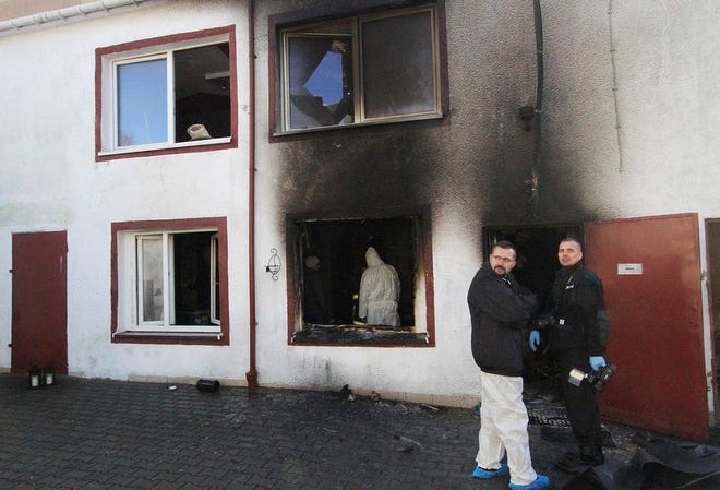 Forensic and other police experts examine the site of a fire in an Escape Room, in Koszalin, northern Poland, on Saturday, Jan. 5, 2019. Investigators in Poland on Saturday blamed a gas leak in a heating system at an "Escape Room" for a fire that killed five teenage girls and injured a man.