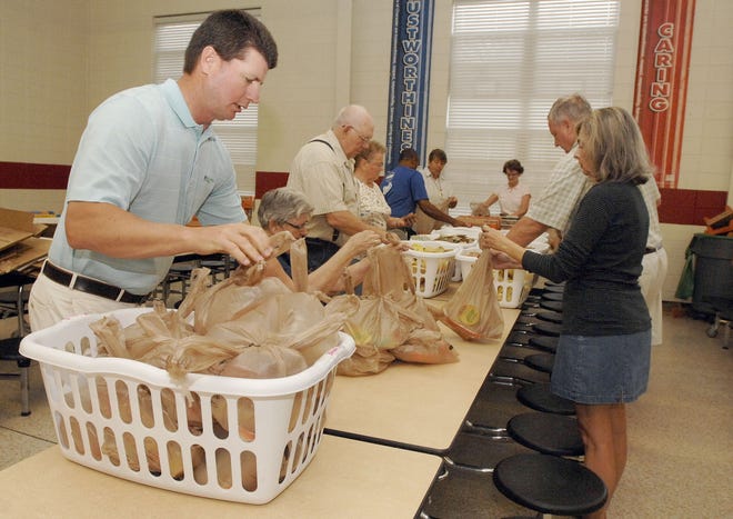 In this 2013 photo, Scott Reid, director of the McGladrey Classic golf tournament in Sea Island, Ga., packed bags of food for children to take home for the weekend. The tournament, now known as the RSM Classic, has been hosted for years by PGA Tour golfer Davis Love III and raises money for a wide range of charities supported by the Davis Love Foundation. Love is just one of many golfers who are doing great philanthropic work — and so does the PGA Tour, which is based in Ponte Vedra Beach. (Florida Times-Union)