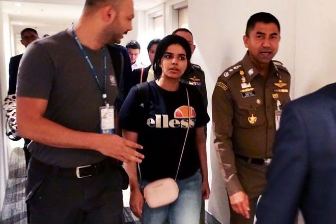 This handout picture taken and released by Thai Immigration Bureau on Monday shows 18-year-old Saudi woman Rahaf Mohammed Alqunun, center, being escorted by the Thai immigration officer and United Nations High Commissioner for Refugees (UNHCR) officials at the Suvarnabhumi international airport in Bangkok. [Thai Immigration Bureau]