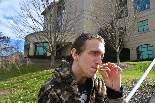 THING OF THE PAST? — Frankie Daniel of Randleman smokes in front of the Randolph County Courthouse. Commissioners are considering a ban on the practice. (Paul Church/The Courier-Tribune)