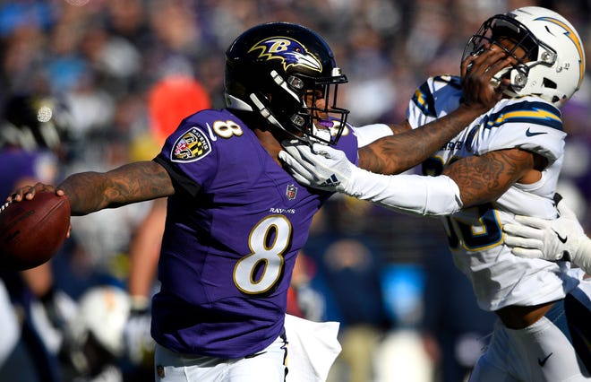 Baltimore Ravens quarterback Lamar Jackson (8) tries to break free from Los Angeles Chargers free safety Derwin James in the first half of an NFL wild card playoff football game, Sunday, Jan. 6, 2019, in Baltimore. (AP Photo/Nick Wass)