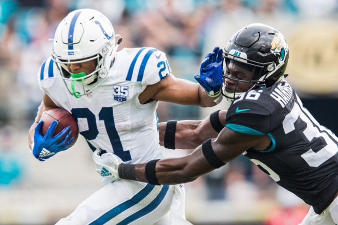 Indianapolis Colts running back Nyheim Hines (21) stiff arms Jacksonville Jaguars defensive back Ronnie Harrison (36) in the fourth quarter. The final score was 6-0 Jaguars. The Jacksonville Jaguars hosted the Indianapolis Colts at TIAA Bank Field In Jacksonville, Florida Sunday, December 2, 2018. [James Gilbert/For the Times-Union]