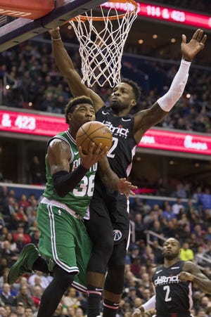 Boston Celtics guard Marcus Smart goes for a reverse layup as Washington Wizards forward Jeff Green defends in a game from earlier this season. [ALEX BRANDON/THE ASSOCIATED PRESS]