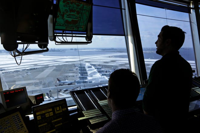 FILE - In this March 16, 2017, file photo, air traffic controllers work in the tower at John F. Kennedy International Airport in New York. The partial government shutdown is starting to effect air travelers. Over the weekend, some airports had long lines at checkpoints, apparently caused by a rising number of security officers calling in sick while they are not getting paid. (AP Photo/Seth Wenig, File)