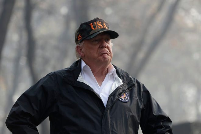 In this Nov. 17, 2018 file photo U.S. President Donald Trump visits a neighborhood impacted by the wildfires in Paradise, Calif. President Trump is threatening to withhold Federal Emergency Management Agency money to help California cope with wildfires if the state doesn't improve its forest management practices. Trump tweeted Wednesday that California gets billions of dollars for fires that could have been prevented with better management.