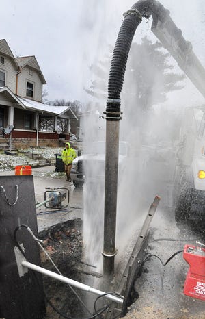 While Cambridge water department employees were changing an old lead water line shut-off on North Seventh Street Wednesday afternoon, a leak occurred. The leak caused a geyser to shoot water about 30 feet in the air. The crews were still working on the leak late Wednesday afternoon. Here, Cambridge water department employee Trent Preece walks by the geyser of a leak on North Seventh Street Wednesday afternoon. The leak occurred while workers were changing an old lead water line shut off on the main six-inch line. The geyser was shooting nearly 30 feet in the air.