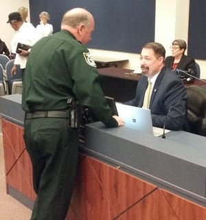 Flagler County Sheriff Rick Staly speaks with County Administrator Craig Coffey prior to Wednesday's meeting. The County Commission agreed to Coffey's proposal that will see him resign as of Friday. [News-Journal/Shaun Ryan]