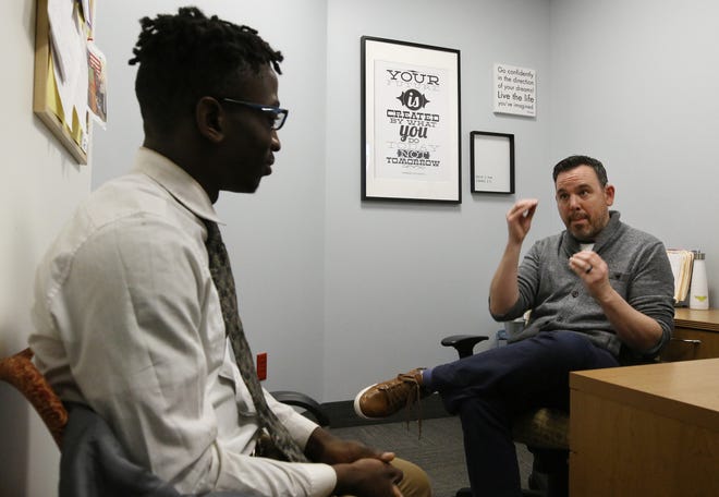 Joseph Batiano, right, the school counselor at the Rhode Island School for the Deaf, talks with Timothy Jallah, a junior at the school. [The Providence Journal / Bob Breidenbach]