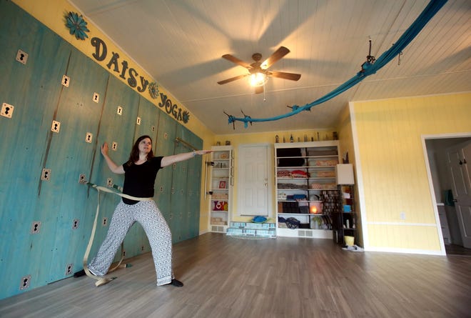 Rhonda Waterhouse works on the yoga wall at Daisy Yoga on Wednesday. [Brittany Randolph/The Star]