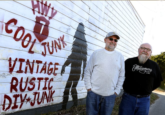 Hwy. 7 Cool Junk owners Rick Gregory, left, and Rodney Alexander outside near the bigfoot mural on the building of their Lowell business. [JOHN CLARK/THE GASTON GAZETTE]