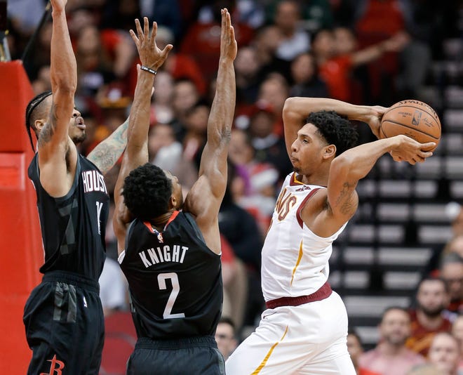 Cleveland Cavaliers guard Cameron Payne, right, passes the ball as Houston Rockets guards Brandon Knight (2) and Gerald Green defend during the first half of an NBA basketball game Friday, in Houston.