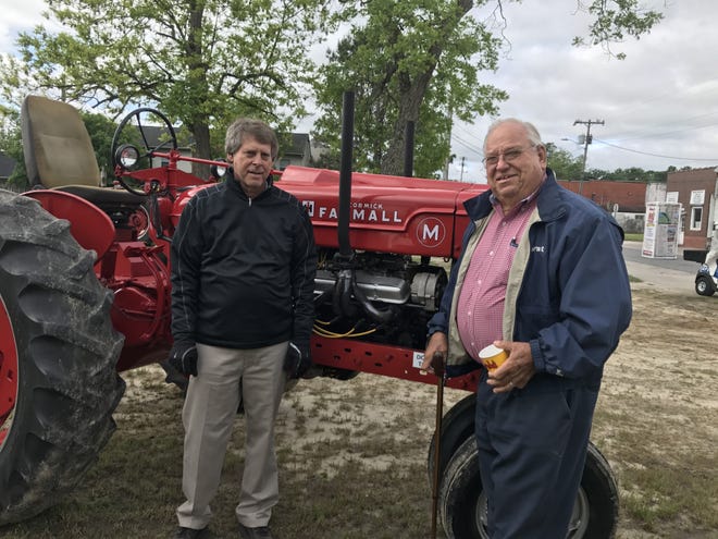 At left, David Mills of Mills international stands next to George Everett and his Farmall M tractor. [Submitted photo]