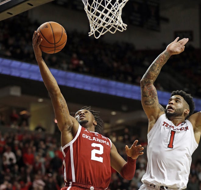 Oklahoma's Aaron Calixte (2) lays up the ball around Texas Tech's Brandone Francis (1) during the second half of a Big 12 Conference game Tuesday at United Supermarkets Arena. Francis finished with eight points, shooting 2-for-3 from the three-point line, to go along with one rebound and one block heading into a 1 p.m. Saturday game at Texas. [Brad Tollefson/A-J Media]