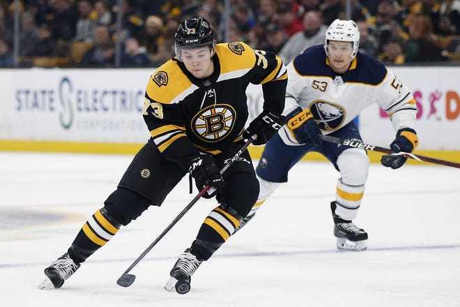 Bruins defenseman Charlie McAvoy (left), shown handling the puck during Boston's game against Buffalo earlier this season, returns to the Bruins' lineup after missing seven games to a leg infection. Saturday's game will be the first time the Bruins will have all of their top-6 defensemen playing in the same game this season. [AP File Photo/Michael Dwyer]
