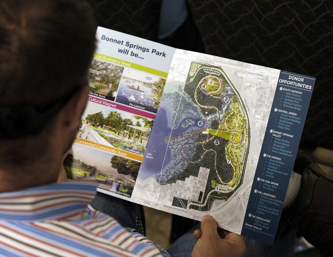 Marc Rachlin looks over a master plan map as he follows the presentation during the unveiling of the vision for Bonnet Springs Park last February. The privately funded park in Lakeland will bring a children's museum, event space, biking trails and more. [PIERRE DUCHARME/THE LEDGER]