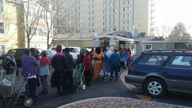 Neighborhood residents line up to receive food at the Metro Ministries Inc., mobile food bank in Denver. [COURTESY PHOTO/METRO MINISTRIES]