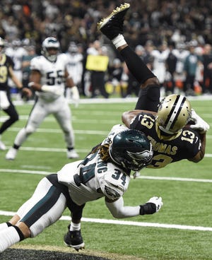 New Orleans receiver Michael Thomas pulls in a touchdown reception against Philadelphia's Cre'von LeBlanc in the third quarter of Sunday's NFC playoff game. The score gave the Saints a 17-14 lead en route to a 20-14 victory and a spot in the the NFC championship game next Sunday against the Los Angeles Rams. [Bill Feig/The Associated Press]