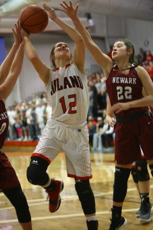 Hiland's Morgan Yoder gets a shot off inside the defense of Newark's Gabby Stare in a game last season.