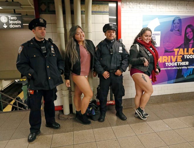 Two women pose for a photograph with a pair of New York City police officers at the Union Square station at the culmination of the 18th annual No Pants Subway Ride, Sunday, Jan. 13, 2019, in New York. The only requirements for the Improv Everywhere-sponsored prank, which started in New York, but is now staged in multiple cities worldwide, are that participants be willing to take their pants off on the subway and keep a straight face about it. (AP Photo/Kathy Willens)
