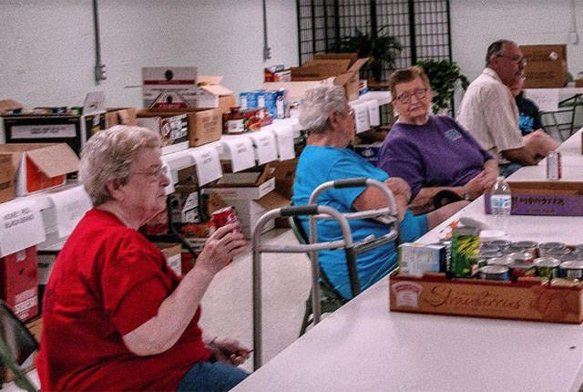 ‘LOVES CHURCH’ — Nancy Brown, left, volunteers at a Shiloh United Methodist Church food drive. She also directs the choir, is responsible for church communications and is the church historian. (Contributed)