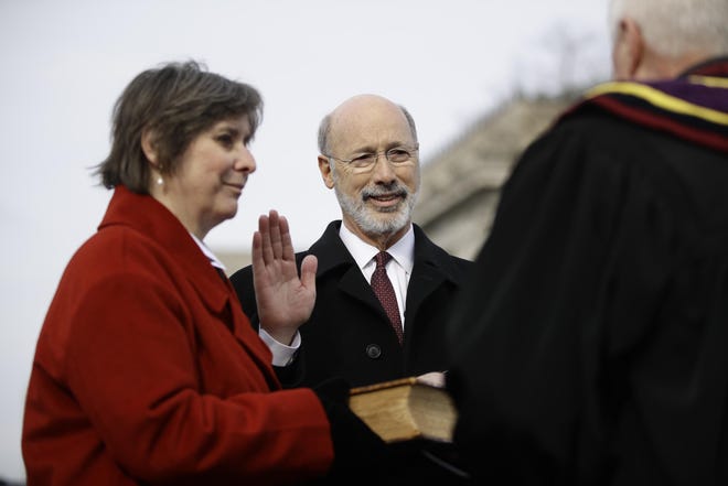 Pennsylvania Gov. Tom Wolf, accompanied by his wife, Frances, takes the Oath of Office as he is sworn in for his second term on Tuesday at the state Capitol in Harrisburg. [ASSOCIATED PRESS/MATT ROURKE]