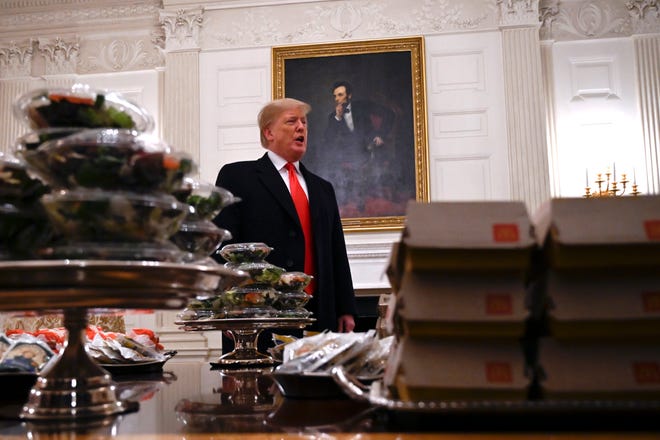President Donald Trump talks to the press about the table full of fast food in the State Dining Room of the White House in Washington, Monday, Jan. 14, 2019, during a reception for the 2018 college football playoff National Champion Clemson Tigers. (AP Photo/Susan Walsh)