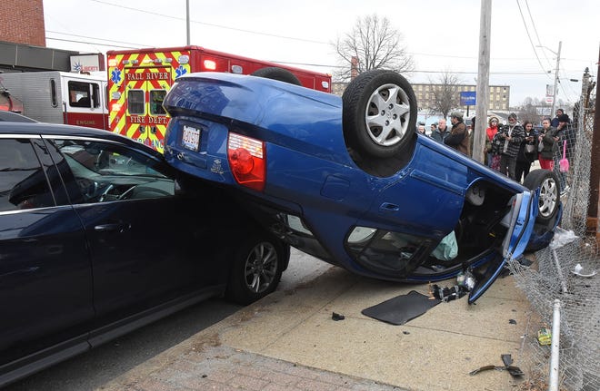 A car came to rest upside-down on the sidewalk and a parked car, with its two ocupants suffering reportedly minor injuries on Pleasant Street, in front of Capital Motors Wednesday, Jan. 19, 2019, in Fall River, Massachusetts. [Herald News Photo | Jack Foley]