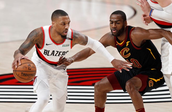 Portland's Damian Lillard (left), who had 33 points, drives against Cleveland's Alec Burks during the first half of Wednesday's game in Portland. The Trail Blazers won 129-112. [AP Photo/Steve Dipaola]