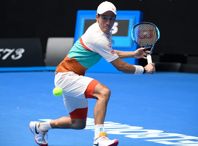 Japan's Kei Nishikori makes a backhand return to Croatia's Ivo Karlovic during his 6-3, 7-6 (6), 5-7, 5-7, 7-6 (7) win in a second-round match at the Australian Open on Thursday in Melbourne, Australia. [AP Photo/Andy Brownbill]