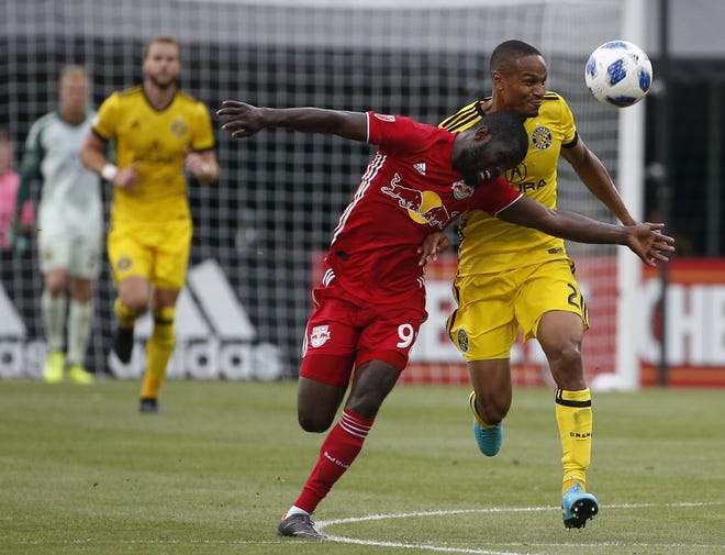In this file photo New York Red Bulls defender Kemar Lawrence (92) and Columbus Crew midfielder Ricardo Clark (2) battle for possession during the second half of a Major League Soccer game between the Columbus Crew SC and the New York Red Bulls on Saturday, June 9, 2018 at Mapfre Stadium in Columbus, Ohio. [Photo by Joshua A. Bickel]
