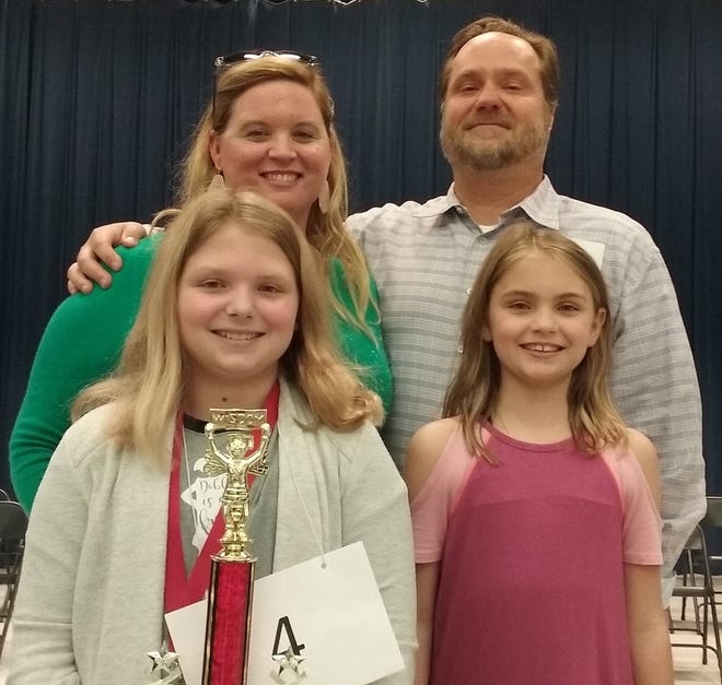 Old Kings Elementary fifth-grader Addison Davis holds her trophy after winning the 2019 Flagler School District Spelling Bee. Standing with her are, clockwise from top left, mom Lesley Davis, dad Josh Davis and sister Macy Davis. [News-Journal/Shaun Ryan]
