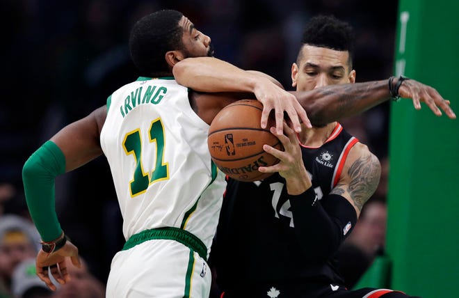 Boston Celtics guard Kyrie Irving (11) and Toronto Raptors guard Danny Green, right, tangle as they compete for the ball during the first quarter of an NBA basketball game in Boston, Wednesday, Jan. 16, 2019. (AP Photo/Charles Krupa)