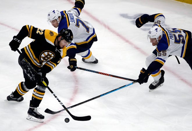Boston Bruins left wing Peter Cehlarik (22) competes for the puck with St. Louis Blues center Oskar Sundqvist (70) and defenseman Colton Parayko (55) during the first period of an NHL hockey game Thursday, Jan. 17, 2019, in Boston. (AP Photo/Elise Amendola)