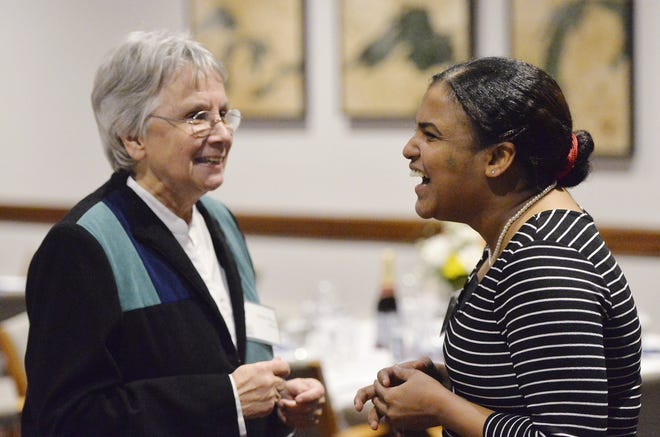 At the first The People's Supper in Erie, Benedictine Sister Mary Miller, 77, left, meets Walaa Ahmad, 31, at the Erie Insurance Events Center on Thursday. [GREG WOHLFORD/ERIE TIMES-NEWS]
