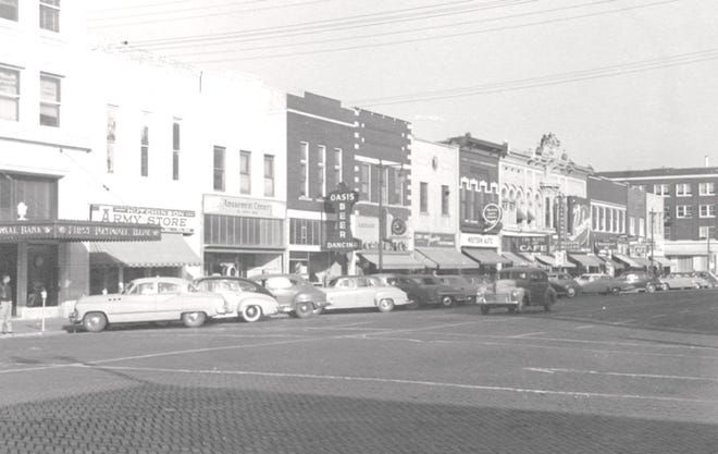 In 1950 on Hutchinson's Main Street, businesses from left to right were First National Bank, Army Surplus, Amusement Center, Oasis Beer, Cantwell's & Corey Jewelers, Western Auto and The Bootery. [Conard - Harmon Collection]