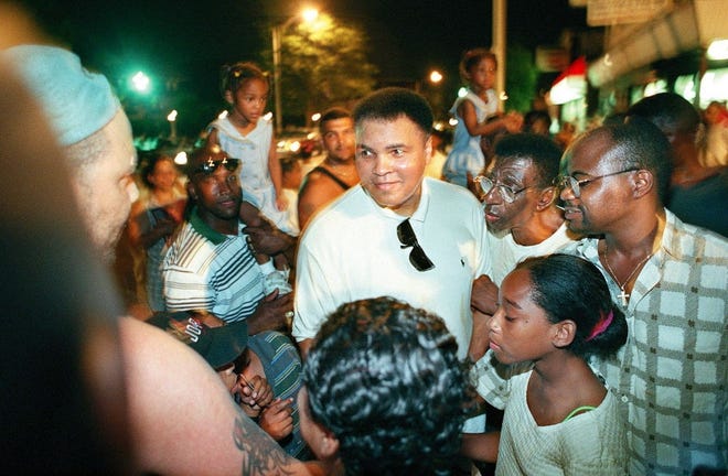Muhammed Ali signs autographs at the corner of Broad and Stanwood streets in Providence in 1997. Ali drew a huge crowd when he visited the city with the crowd sometimes blocking traffic on Broad Street. Fans chanted, "Ali, Ali." 

 [The Providence Journal, file / Andrew Dickerman]