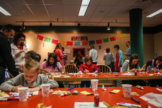 People enjoy free arts and crafts, entertainment, and refreshments, during the Dia De Los Muertos Celebration on Saturday, October 24, at the Springfield Public Library. (Mary Jane Schulte/The Register-Guard)