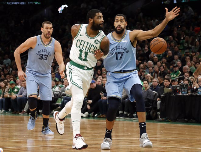 Boston Celtics' Kyrie Irving throws a behind-the-back pass past Memphis Grizzlies' Garrett Temple (17) during the first quarter of an NBA basketball game Friday, Jan. 18, 2019, in Boston. (AP Photo/Winslow Townson)