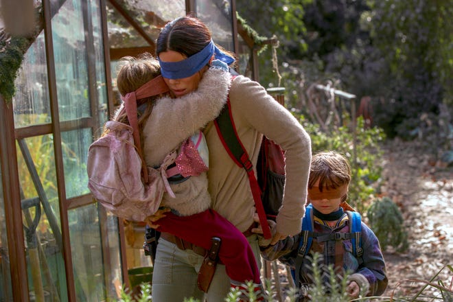 This image released by Netflix shows Sandra Bullock in a scene from the film, "Bird Box." Netflix’s post-apocalyptic survival film is drawing criticism for using footage of a real fiery train disaster but the streaming giant has no plans to remove it. The footage concerns a 2013 tragedy in the Quebec town of Lac-Megantic when an unattended train carrying crude oil rolled down an incline, came off the tracks and exploded into a massive ball of fire, killing 47 people. (Saeed Adyani/Netflix via AP)