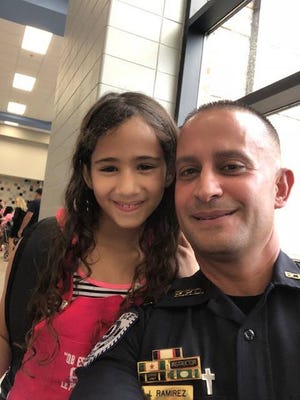 A student posed with then-interim police Chief Jose Ramirez when he distributed backpacks in July. [FILE PHOTO]