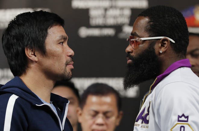Manny Pacquiao, left, and Adrien Broner pose for photographers during a news conference Wednesday in Las Vegas. The two are scheduled to fight in a welterweight championship bout on Saturday. [JOHN LOCHER/THE ASSOCIATED PRESS]