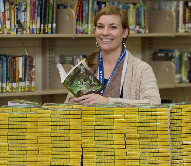 South Davidson Middle School media specialist Mary Howell stands with the 350 copies of a book she obtained with a $1,000 grant she earned for the "One Book, One School" reading campaign. [Donnie Roberts/The Dispatch]