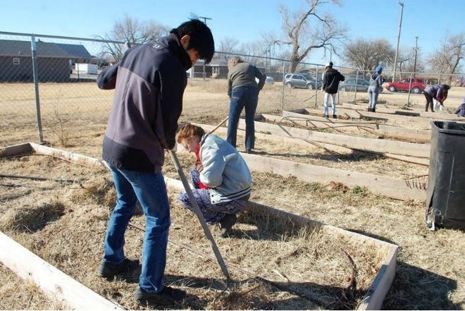 Caleb Powell and Emma Whitfill came out to volunteer to help pick up trash and pull weeds at the Booker T. Washington community garden in East Lubbock to commemorate Martin Luther King Jr. Day, Jan. 15, 2018. [Erica Pauda/A-J Media]