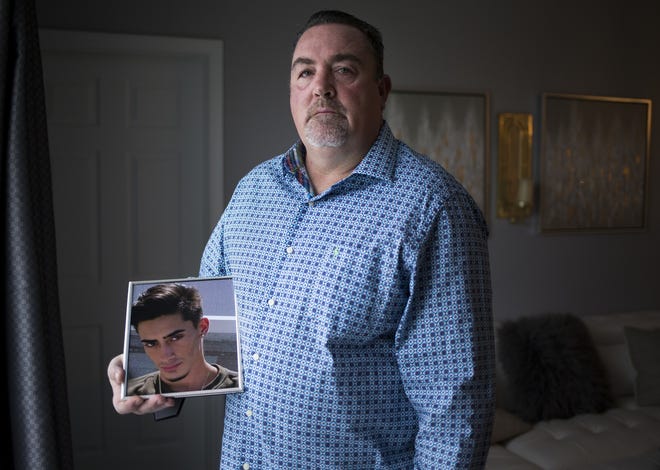 Rob Rivard holds a photo of his stepson Chris Machesney at his home in Tampa. Machesney committed suicicde last November when he jumped from the Sunshine Skyway Bridge. There were a record number of suicides from the Skyway bridge in 2018. [MONICA HERNDON/TAMPA BAY TIMES VIA AP]