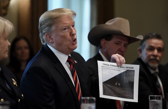 President Donald Trump shows a border wall design during a roundtable discussion on border security at the White House on Jan. 11. [ABACA PRESS]