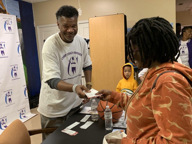 Keith Rhodes gives away tickets to a Gardner-Webb basketball game to a family whose students had at least a B average in school. [Dustin George / The Star]