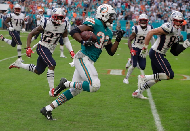 Miami Dolphins running back Kenyan Drake (32) runs for a game-winning touchdown against the New England Patriots last month.
.